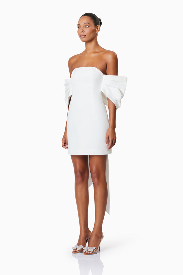 model wearing CALYPSO BOW DETAIL MINI DRESS IN WHITE side shot