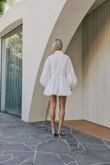 blonde model wears CURAAE Vienna Bubble Low Waist Skirt Long Sleeve Shirt Dress In White back shot