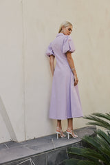 blonde model wears CURAAE Bay Midi Shirt Puff Sleeve A Line Dress In Lilac back shot