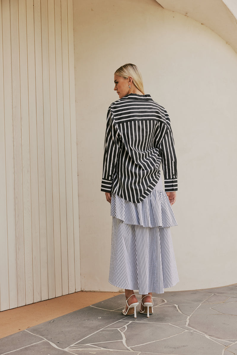 blonde model wears CURAAE Capri Midi Frill Asymmetrical High Waisted Skirt In Lilac & White Stripe back shot