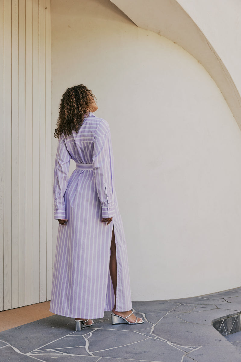 brunette model wears CURAAE Jasmine Maxi Shirt Tie A Line Dress In Lilac Stripe back shot