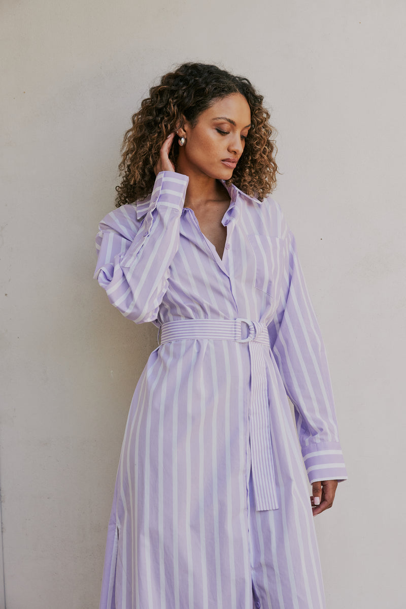 brunette model wears CURAAE Jasmine Maxi Shirt Tie A Line Dress In Lilac Stripe mood shot