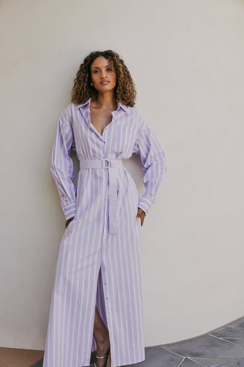 brunette model wears CURAAE Jasmine Maxi Shirt Tie A Line Dress In Lilac Stripe mood shot