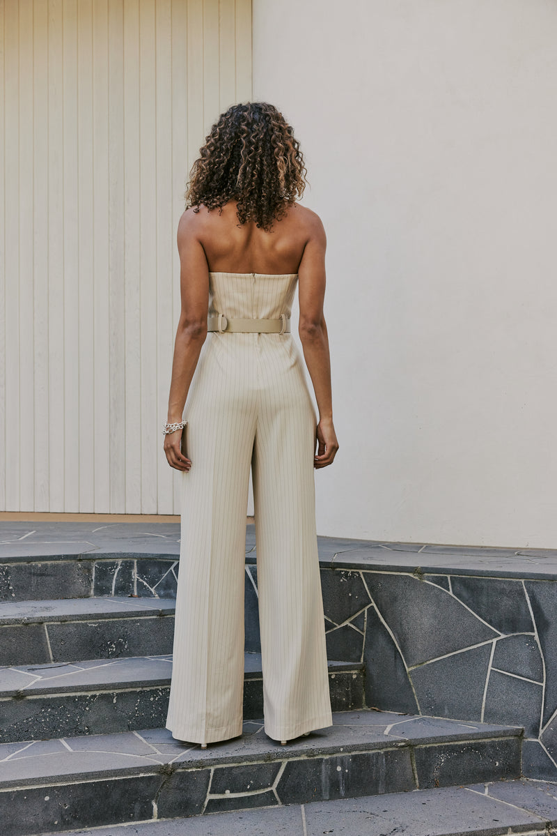 Model wearing Seraphina Pinstripe Jumpsuit In Beige back shot 