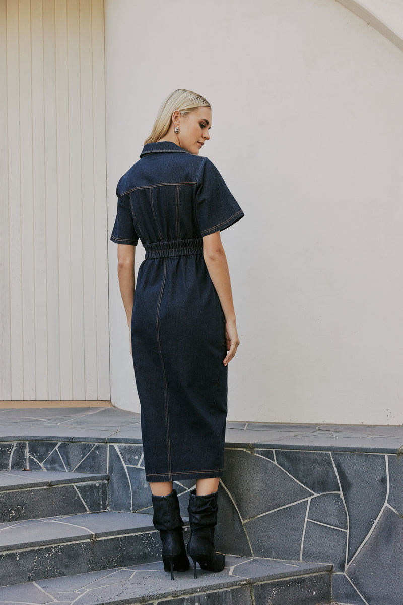 blonde model wears CURAAE Elysia Midi Shirt Belt Denim Dress In Ink back shot