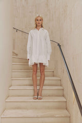 Blonde model wears Eloise Tiered Shirt Dress in White front shot