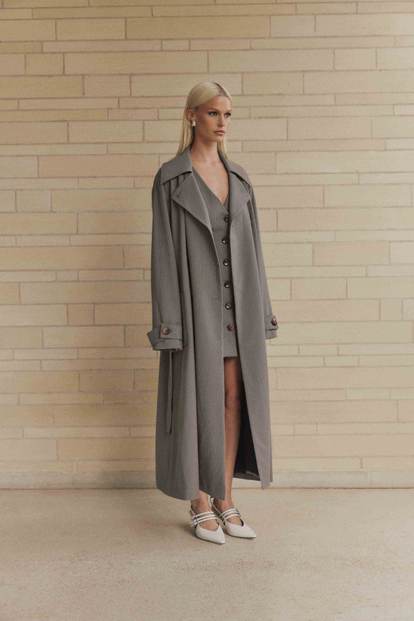 Blonde model wearing London Trench Coat In Brown side shot