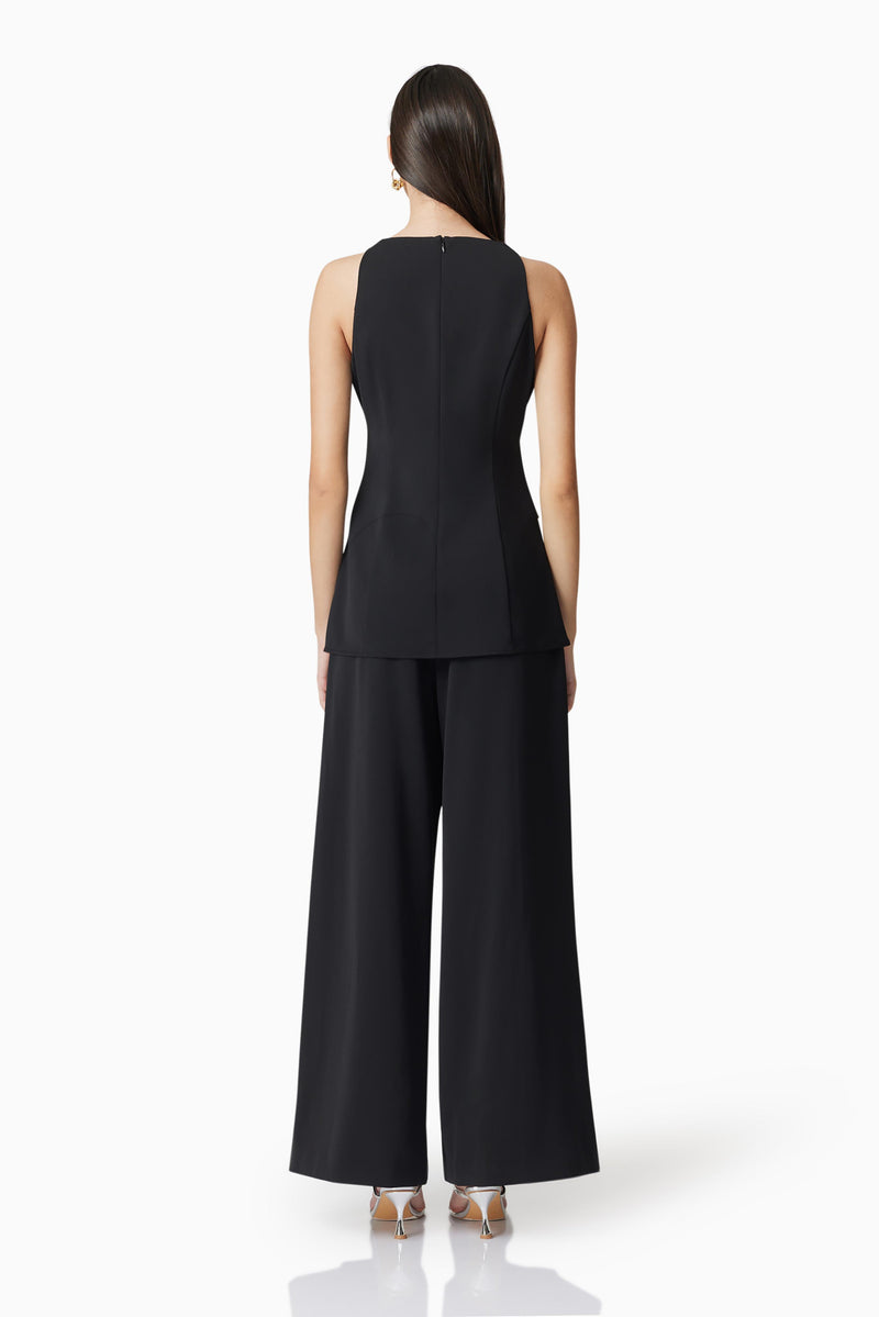 Brunette model wearing Noa Pleated Trousers in Black back shot