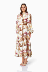 Brunette model wearing MEADOW FLORAL DAY DRESS IN MULTI side shot