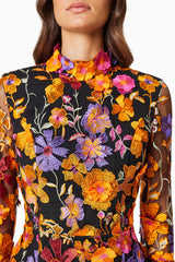 model wearing Alessandra Floral Longsleeve Mini Dress In Orange close up shot