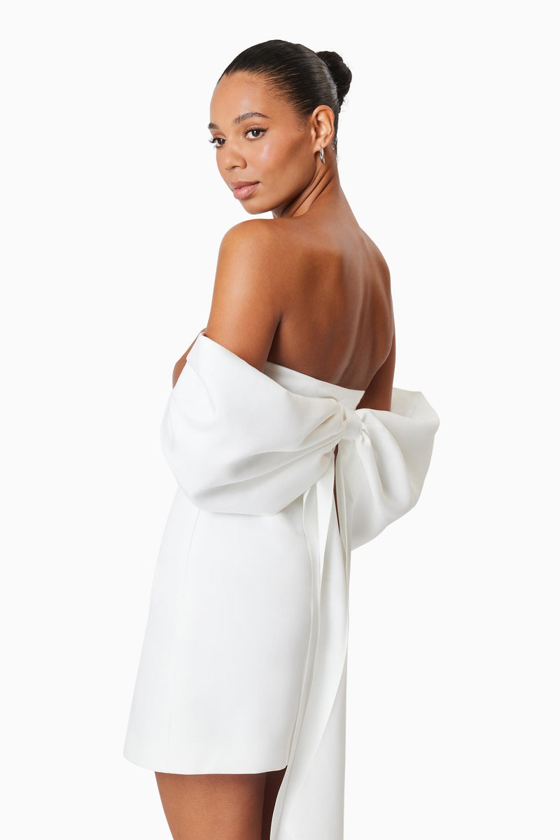 model wearing CALYPSO BOW DETAIL MINI DRESS IN WHITE close up shot
