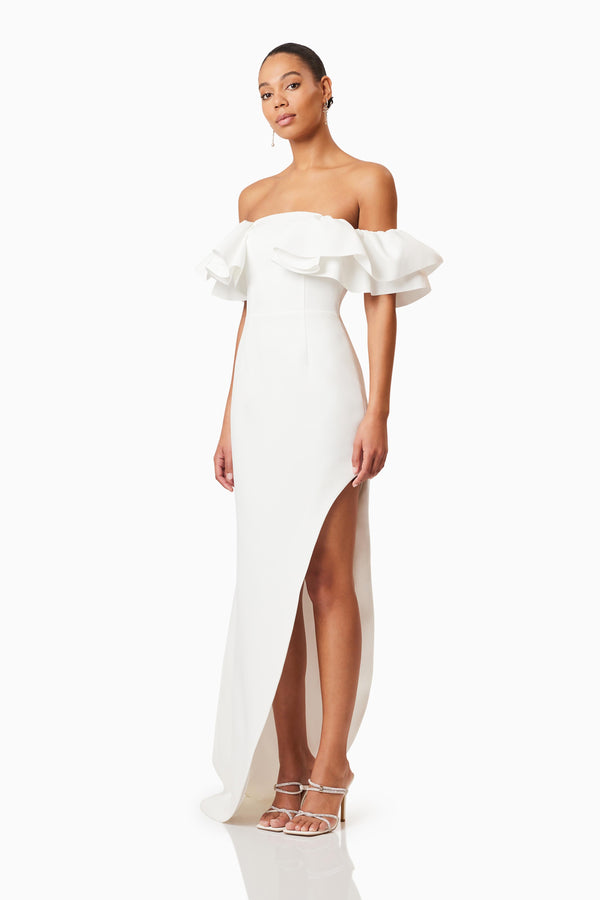 Brunette model wearing Geranium Hilo Off the Shoulder Dress in White side shot