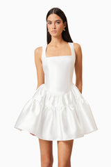 Brunette model wears Oleander Fit And Flare Dress In White close front shot