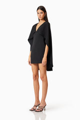 Brunette model wearing Lilydale Cape Mini Dress In Black side shot