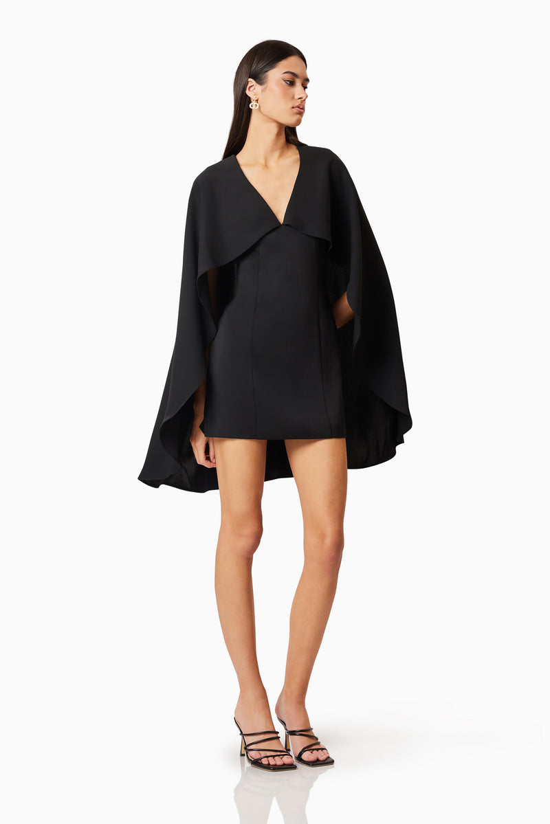 Brunette model wearing Lilydale Cape Mini Dress In Black posed shot