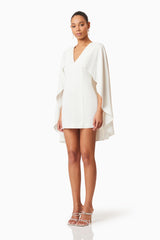 Brunette model wearing Lilydale Cape Mini Dress In White side shot