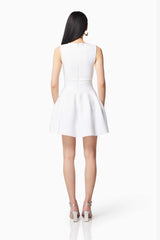 Brunette model wearing MAGNETISM ROUNDED NECKLINE MINI DRESS IN WHITE back shot